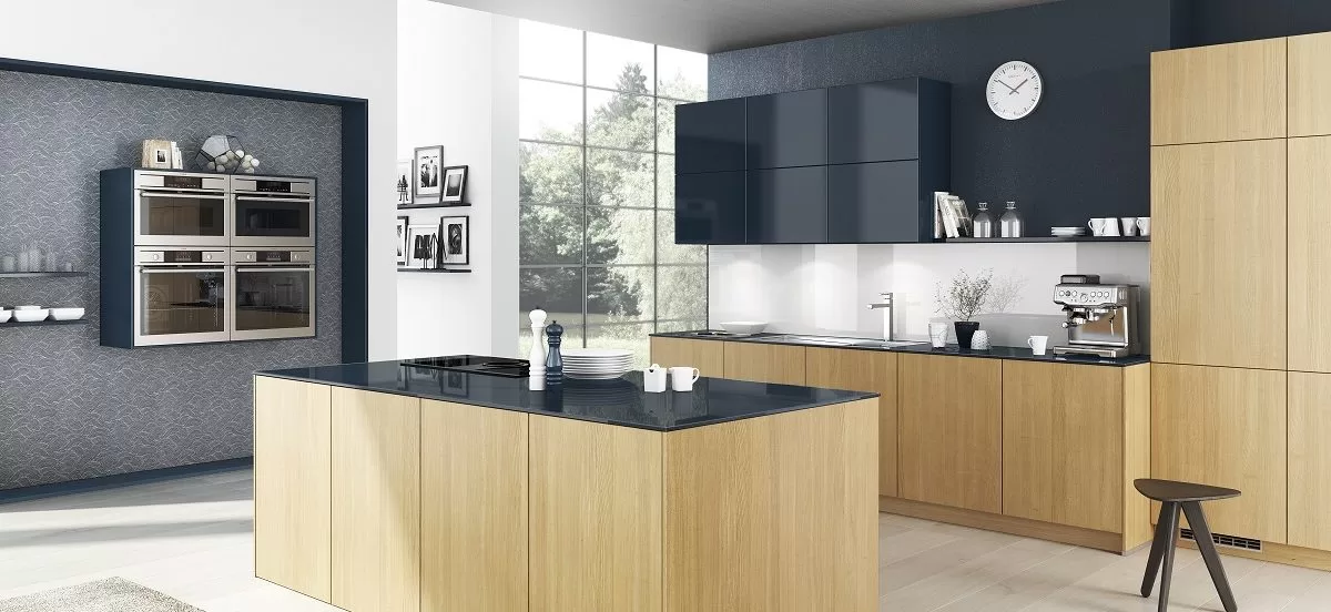 Moderne grifflose Küche ohne Zehentritt aus hellem Eichenholz und kontrastierendem Hochglanz-Marineblau-Finish