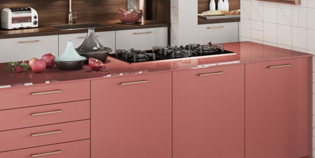 Salmon pink modern kitchen with brass handles and pink glass countertop